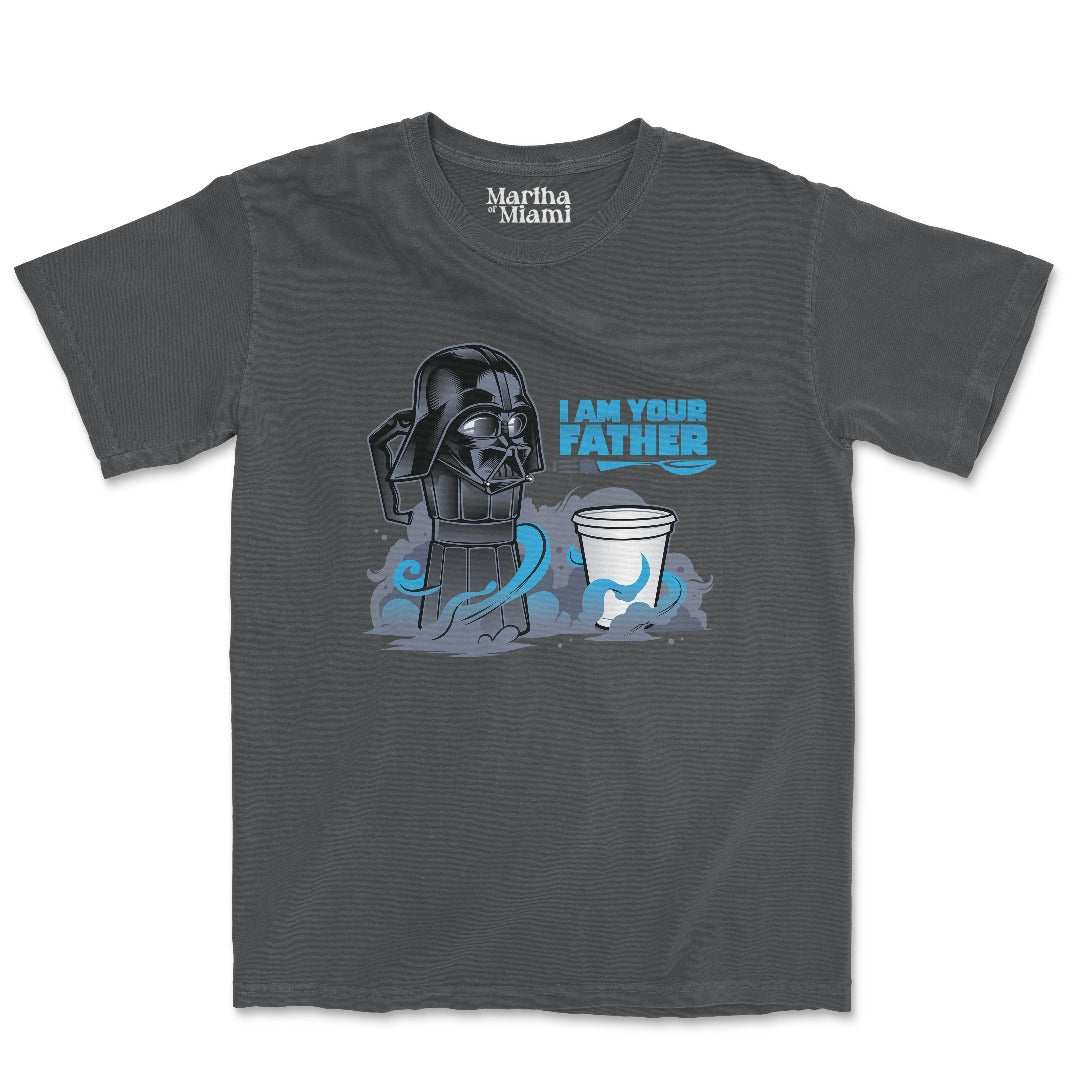 A graphite-colored t-shirt from Martha of Miami featuring a humorous design. The graphic shows a moka coffee pot styled as a famous sci-fi character, with the phrase "I Am Your Father" in bold blue text next to it. Below the moka pot is a small Cuban coffee cup, implying a playful father-child relationship between the coffee pot and cup. The Martha of Miami logo is printed on the inside collar of the shirt.