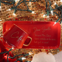 an image of a red coffee mug and a red dish plate that says dear santa, I'm sure Mrs. Claus tiene comida en la cada but just in case!